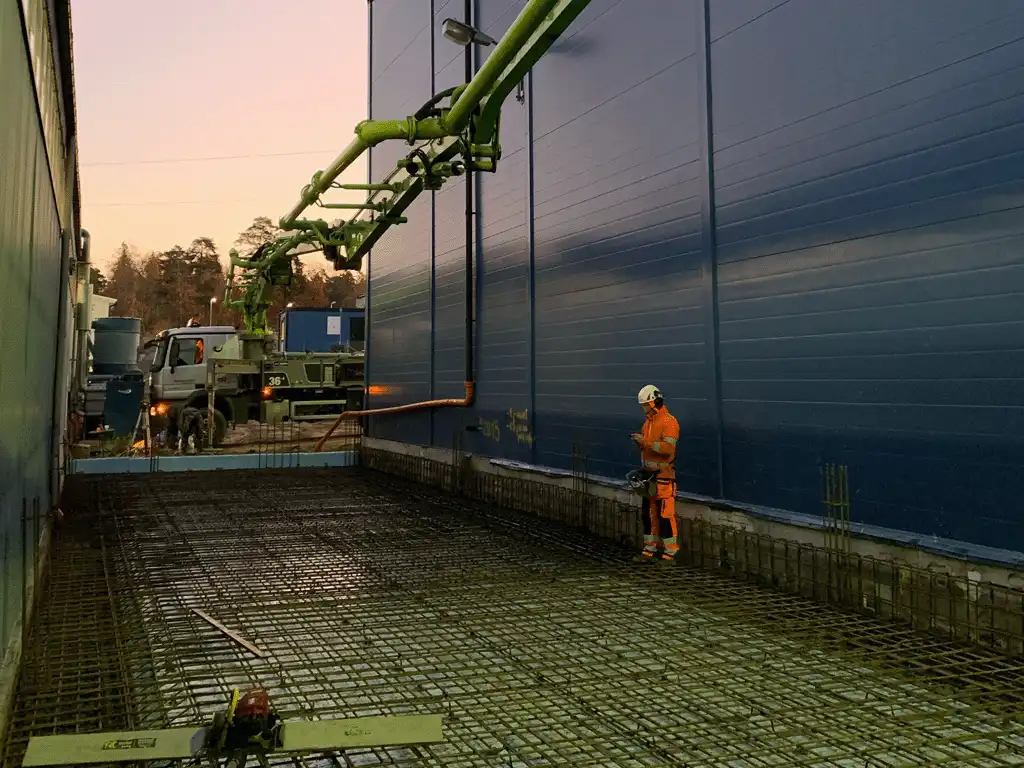 
gjuta betong från en betongblandarfabrik. På det här fotot är en person och Fukacmty och en betongblandarbil.
